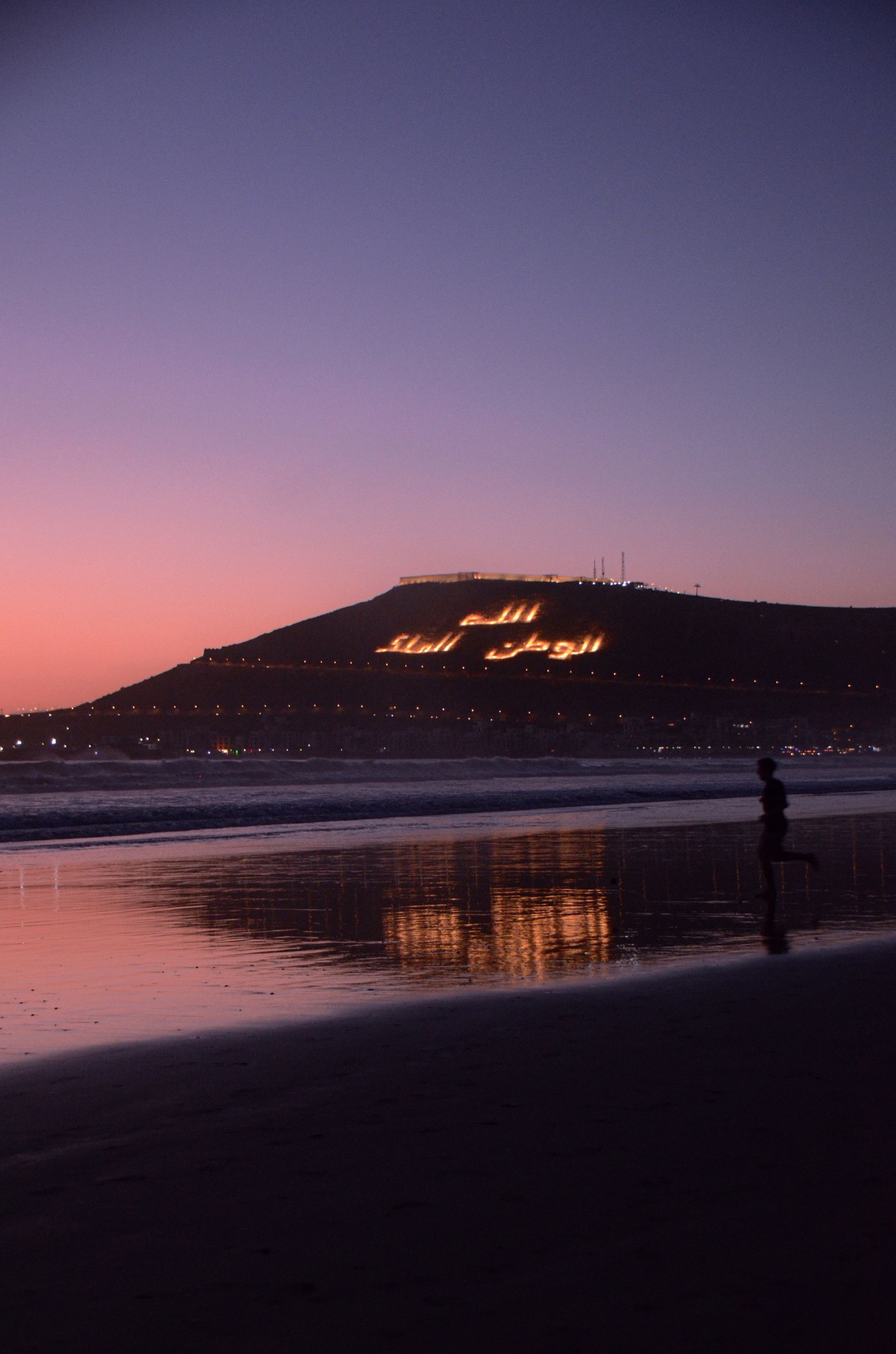 Plage d'Agadir au coucher du soleil, colline d'Agadir Oufella illuminée