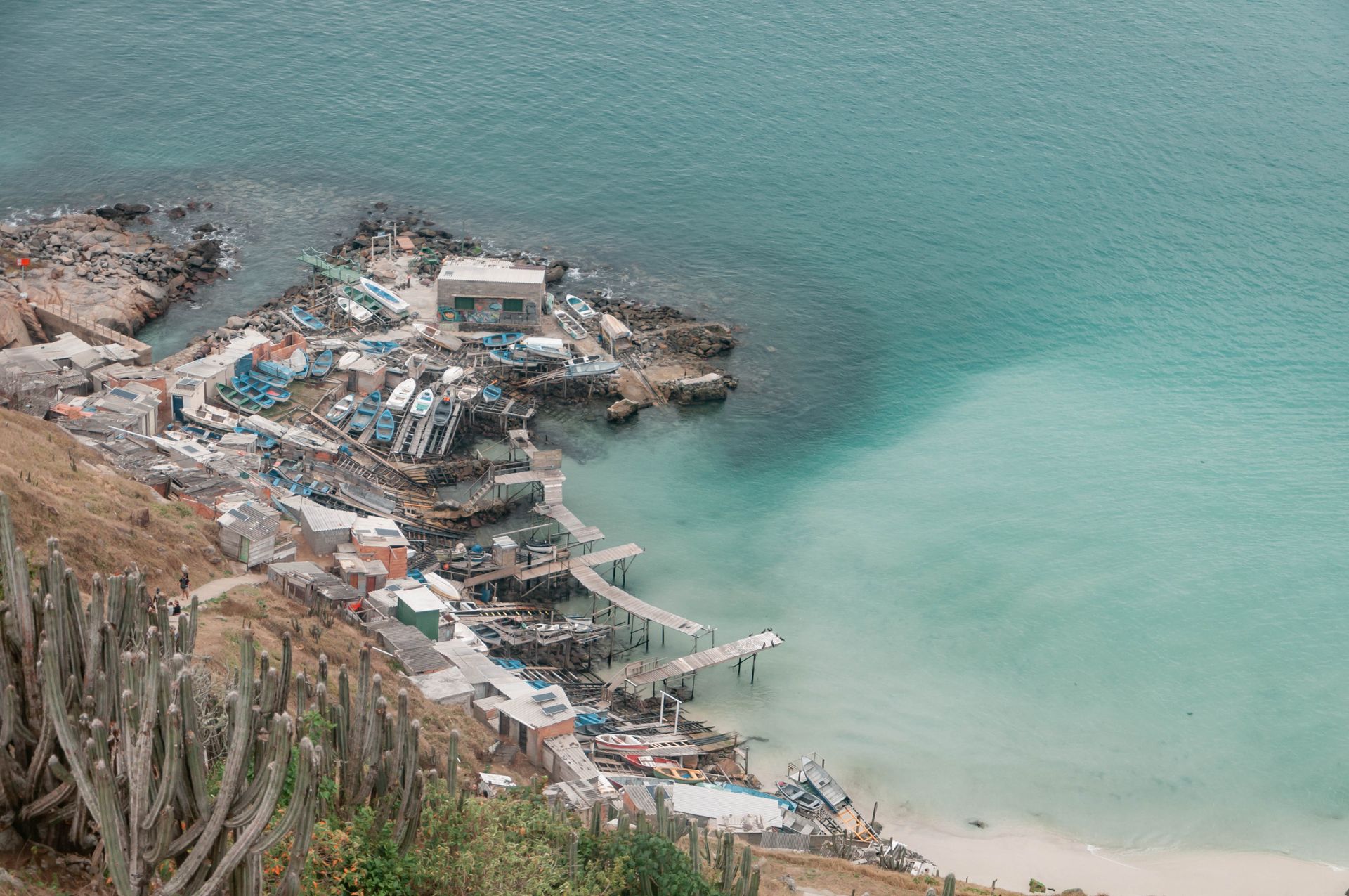 Village de pêcheurs du Cap-Vert accroché à une côte rocheuse, barques bleues et eau turquoise